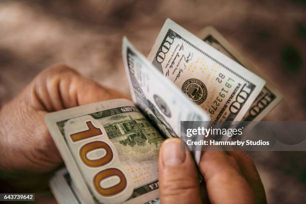 onherkenbaar volwassen man vs dollarbiljetten tellen - american one hundred dollar bill stockfoto's en -beelden