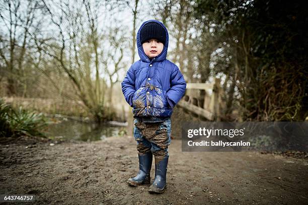 boy covered in mud in countryside. - jeans for boys stock pictures, royalty-free photos & images