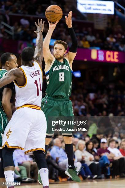 Matthew Dellavedova of the Milwaukee Bucks shoots over DeAndre Liggins of the Cleveland Cavaliers during the first half at Quicken Loans Arena on...