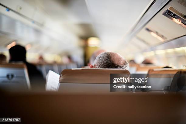 man on airplane. - airplane seat back stock pictures, royalty-free photos & images