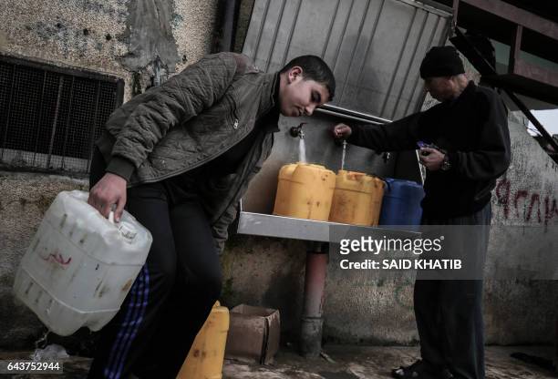 Palestinians fill bottles and jerricans with drinking water from public taps at the Rafah refugee camp in southern Gaza Strip, on February 22, 2017.