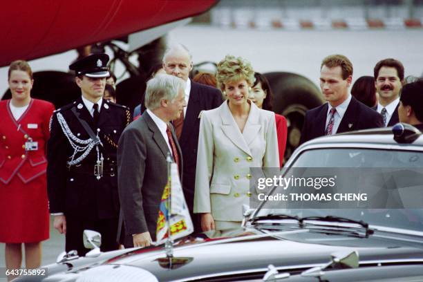 Princess Diana makes a funny face after Hong Kong Governor Chris Patten shows her the direction of the press group covering her arrival on April 21,...