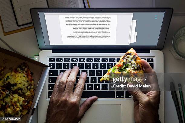 hand holding a pizza while working on a laptop - david swallow stock pictures, royalty-free photos & images