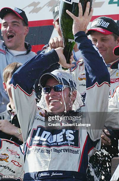 Jimmie Johnson, driver of the Hendrick Motorsports Chevrolet Monte Carlo pours Champagne on his in head in victory circle on JUNE 2, 2002 after...