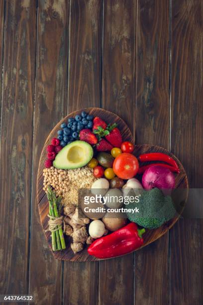 healthy food on a heart shape cutting board - healthy eating stock pictures, royalty-free photos & images