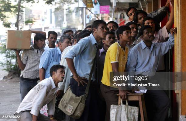 Cricket - Fans and Spectators - Watching Match on Television - Pedestrians and cricket fans watch the last over in the live telecast of cricket match...