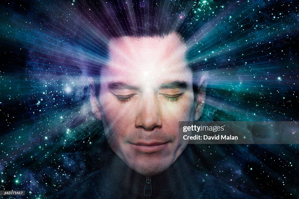 Man meditating with light radiating from him