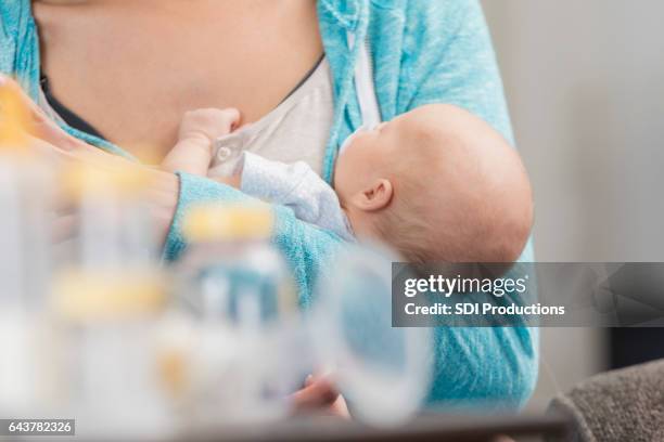 new mom cradles her newborn baby girl - lactating women stock pictures, royalty-free photos & images