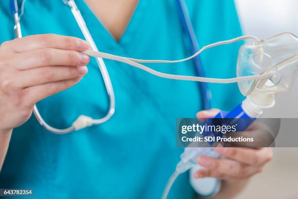nurse holds a nebulizer - respiratory system stock pictures, royalty-free photos & images