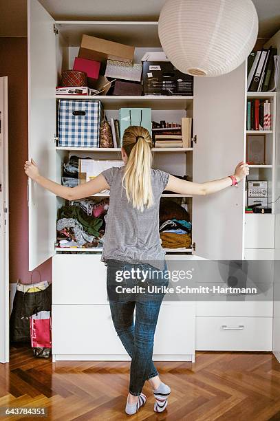 young woman looking into her cabinet - organize home stock pictures, royalty-free photos & images