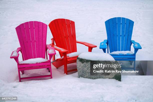 colourful muskoka chairs on snowy beach - muskoka stock pictures, royalty-free photos & images