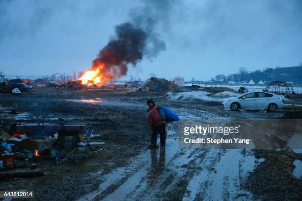 Campers set structures on fire in preparation of the Army Corp's 2pm deadline to leave the Oceti Sakowin protest camp on February 22, 2017 in Cannon...