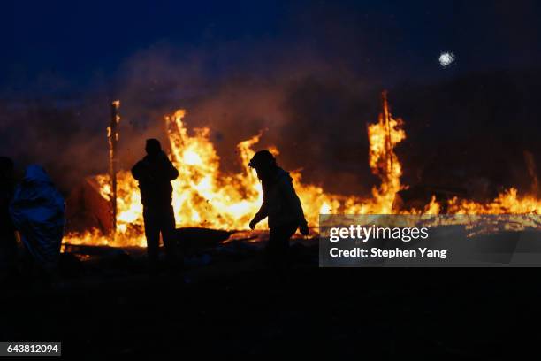 Campers set structures on fire in preparation of the Army Corp's 2pm deadline to leave the Oceti Sakowin protest camp on February 22, 2017 in Cannon...