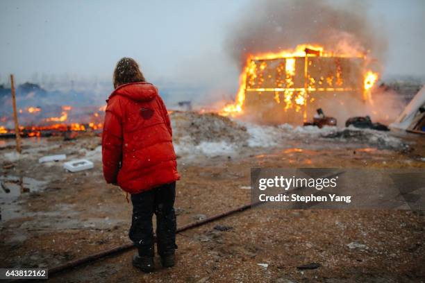 Campers set structures on fire in preparation of the Army Corp's 2pm deadline to leave the Oceti Sakowin protest camp on February 22, 2017 in Cannon...