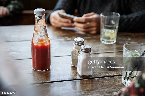 salt and pepper at the table on a bar/pub - tomatenketchup stockfoto's en -beelden