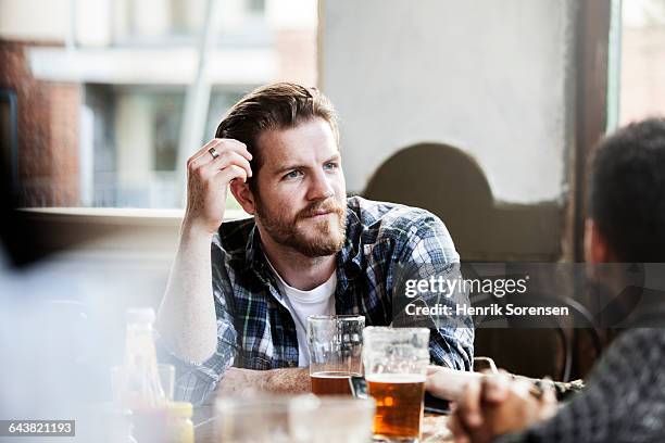 man in conversation in a pub - amigos bar fotografías e imágenes de stock