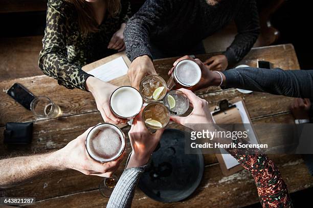 friends at a pub toasting - alcohol top view stock-fotos und bilder