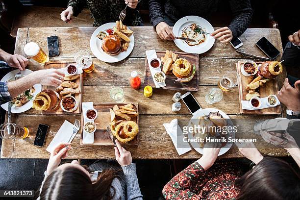 friends at a pub eating, birds view - burger above stock pictures, royalty-free photos & images