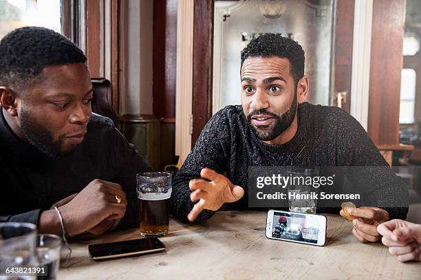 man sharing video on his phone - beer pub stock pictures, royalty-free photos & images