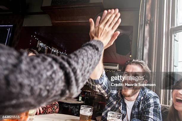 two friends doing a high five - happy hour stockfoto's en -beelden