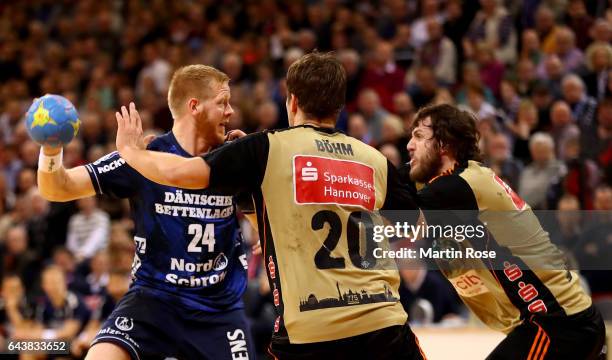 Jim Gottfridsson of Flensburg challenges Fabian Boehm and Mait Patrail of Hannover-Burgdorf for the ball during the DKB HBL Bundesliga match between...