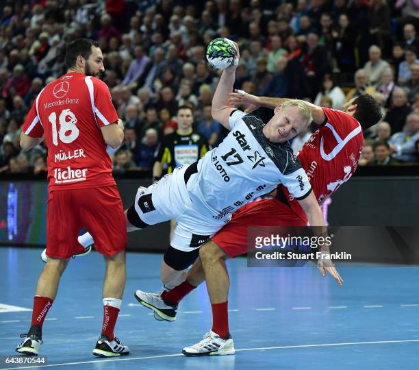 Patrick Wiencek of Kiel is challenged by Michael Mueller of Melsungen during the DKB Handball Bundesliga game between THW Kiel and MT Melsungen at...