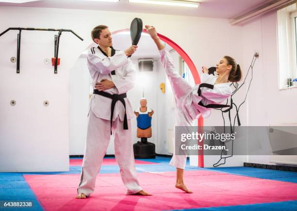 young female taekwondo enthusiast on training, warming up - high kick stock pictures, royalty-free photos & images