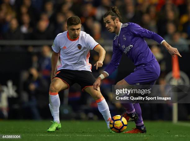 Guillherme Siqueira of Valencia competes for the ball with Gareth Bale of Real Madrid during the La Liga match between Valencia CF and Real Madrid at...