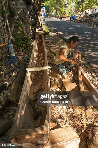 balinese man building boat - c100 stock pictures, royalty-free photos & images
