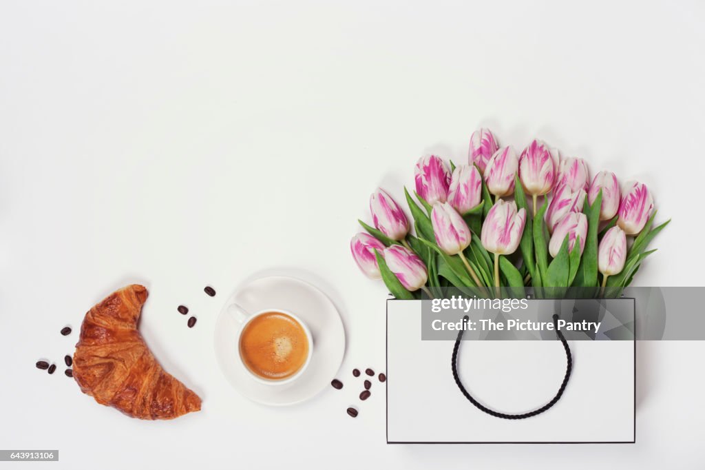 Top view of spring flowers, coffee and croissant. Flat lay image. Holiday, romance of modern life concept