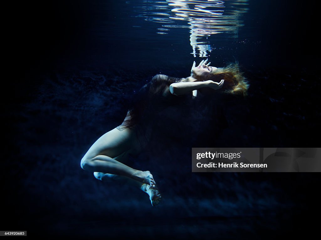 Young woman floating gracefully under water