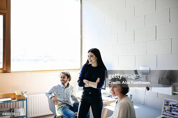 young man and women laughing in studio space - sweatshirt stockfoto's en -beelden