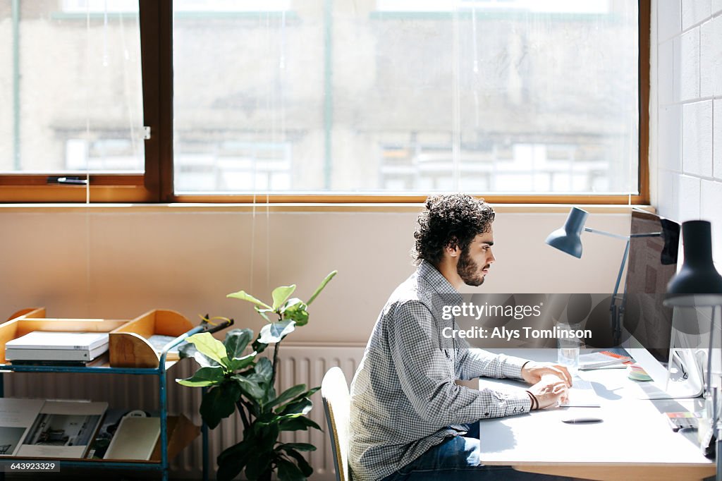 Young man working on computer in studio