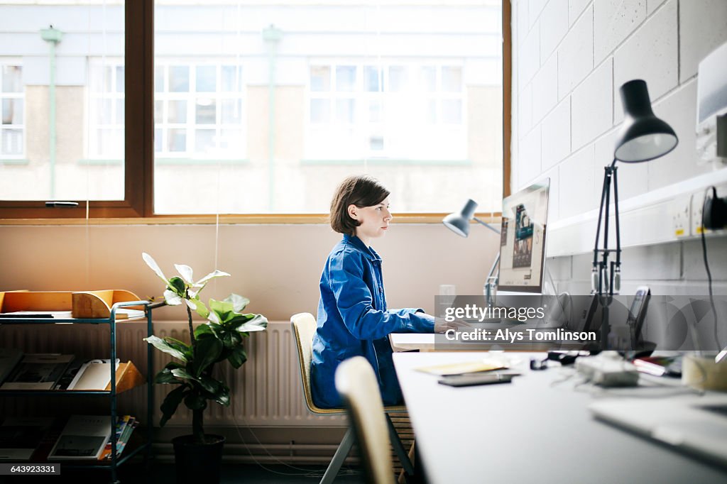 Young woman working at computer in studio