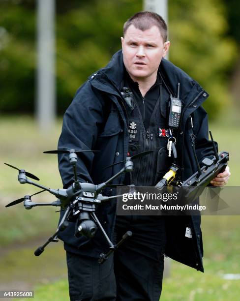 Police Officer armed with a taser flies a camera equipped drone as Catherine, Duchess of Cambridge arrives for a visit to MIST, a child and...