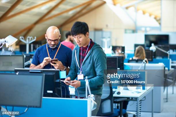 two men using mobile phones in modern office. - mobile technology stockfoto's en -beelden