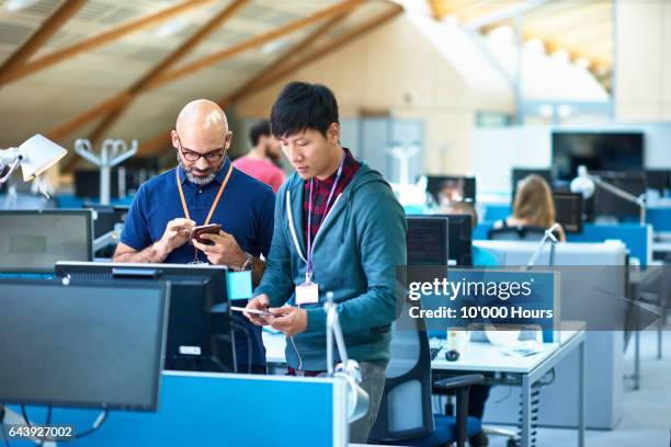 two men using mobile phones in modern office. - telecommunication device stock pictures, royalty-free photos & images