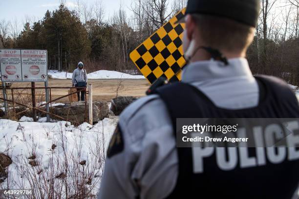 Man claiming to be from Sudan is confronted by a Royal Canadian Mounted Police officer as he prepares to cross the U.S.-Canada border into Canada,...