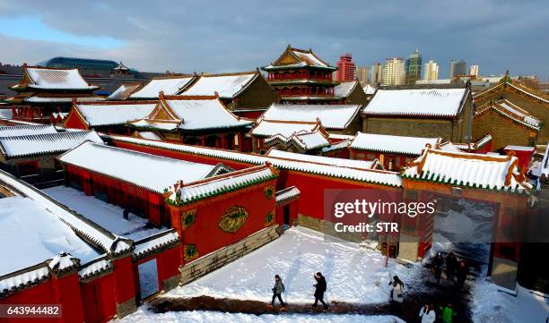 This photo taken on February 22, 2017 shows visitors walking through the Shenyang Imperial Palace, also known as the Mukden Palace, after a snowfall...