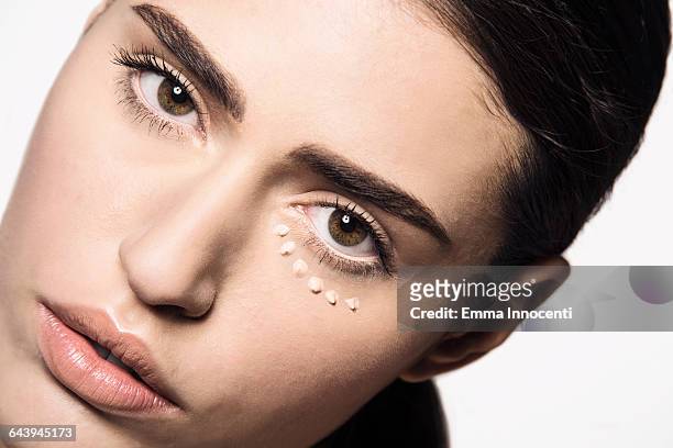 woman with concealer dots under eye - concealer stock pictures, royalty-free photos & images