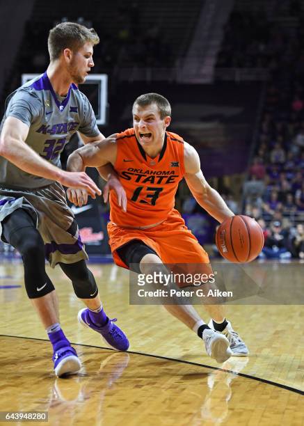 Guard Phil Forte III of the Oklahoma State Cowboys drives to the basket against forward Dean Wade of the Kansas State Wildcats during the first half...