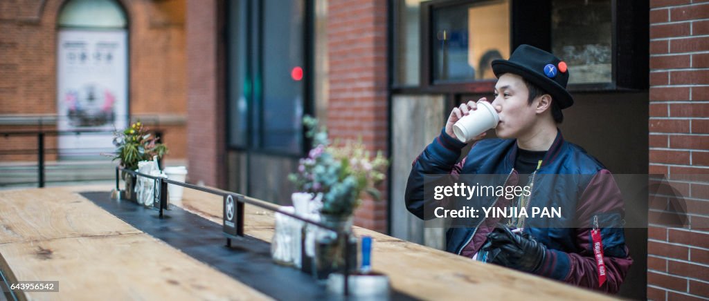 Young man sitting on the bench drinking coffee