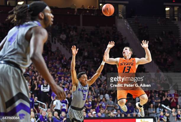Guard Phil Forte III of the Oklahoma State Cowboys loses control of the ball against guard Kamau Stokes of the Kansas State Wildcats during the first...