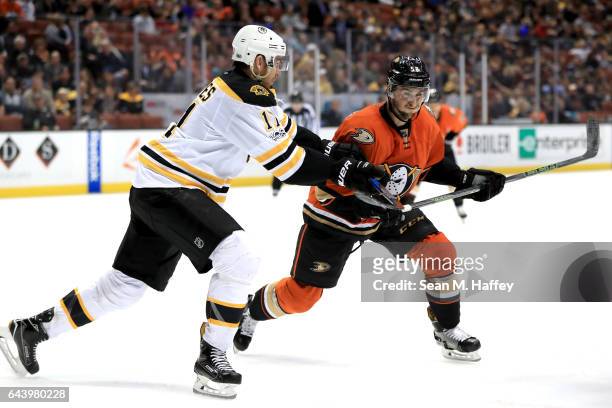 Jimmy Hayes of the Boston Bruins pushes against Nicolas Kerdiles of the Anaheim Ducks during the third period of a game at Honda Center on February...