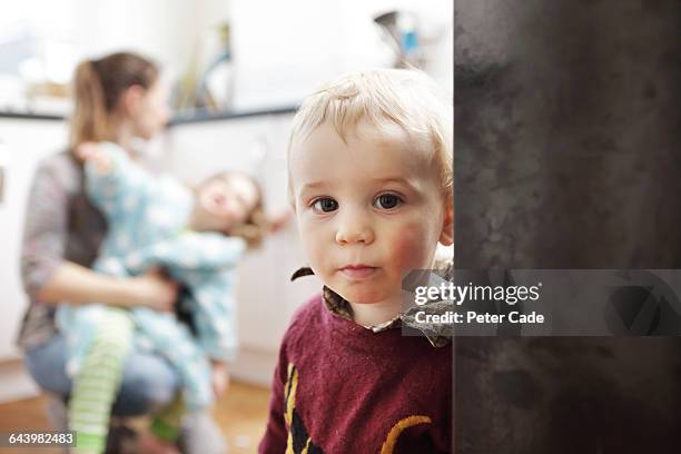 boy looking on as mother struggles with big sister - family looking at camera stock pictures, royalty-free photos & images