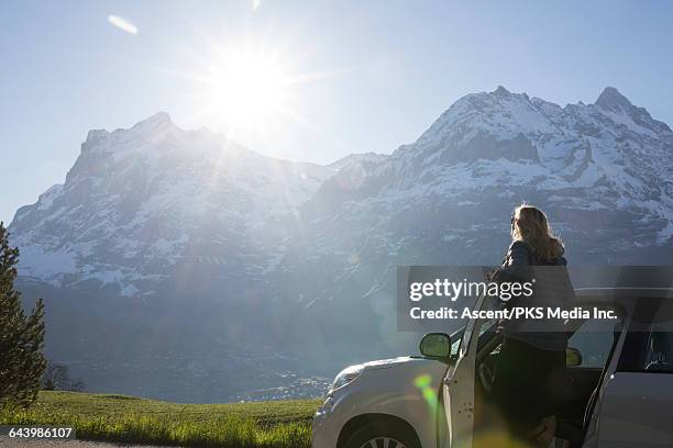 woman stops car to enjoy mountain view, sunrise - standing on top of car stock pictures, royalty-free photos & images