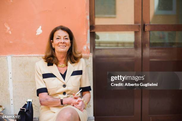 caucasian woman sitting outdoors - beautiful women smoking cigarettes stock pictures, royalty-free photos & images