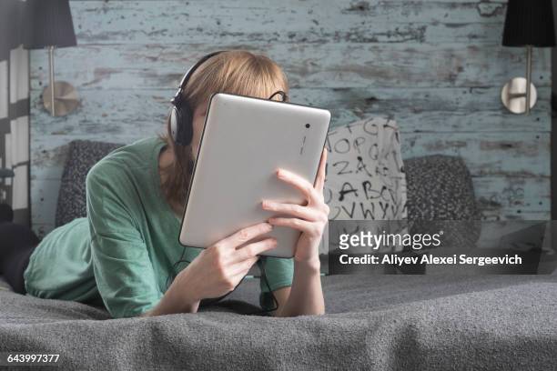 caucasian woman using digital tablet on bed - viso nascosto foto e immagini stock