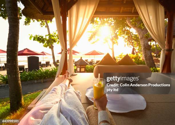 pacific islander woman drinking juice in gazebo - pergola fotografías e imágenes de stock