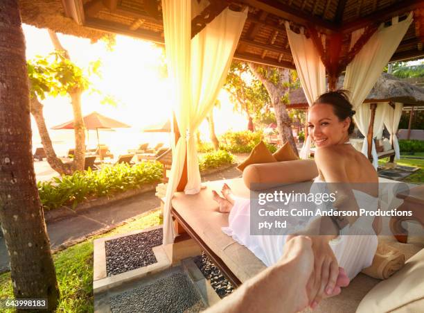 woman pulling boyfriend into gazebo - chaise longue stockfoto's en -beelden